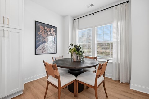 A dining room with a round table and chairs.