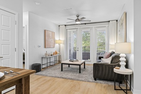 a living room with a couch coffee table and a kitchen in the background
