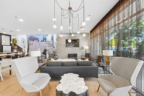 A modern living room with a grey sofa, white chairs, and a coffee table.