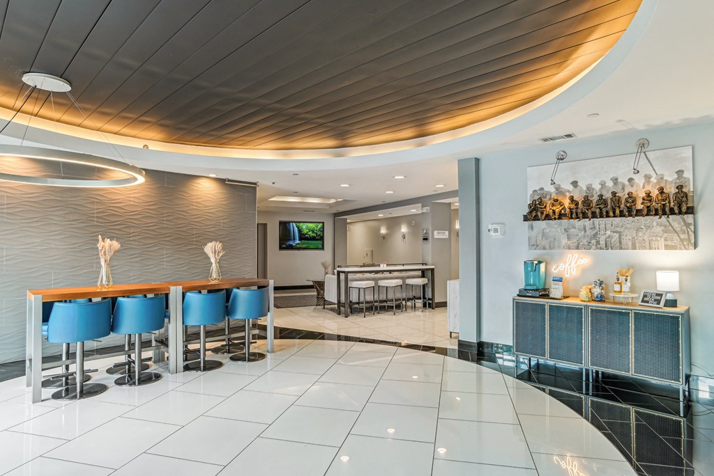 a bar with blue chairs and a table in a lobby