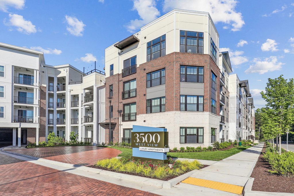 a large apartment building with a sign in front of it