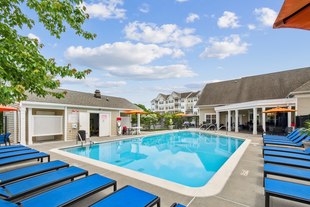 A pool surrounded by sun loungers and umbrellas.