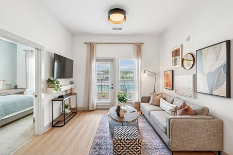 A living room with a couch, a coffee table, and a television.