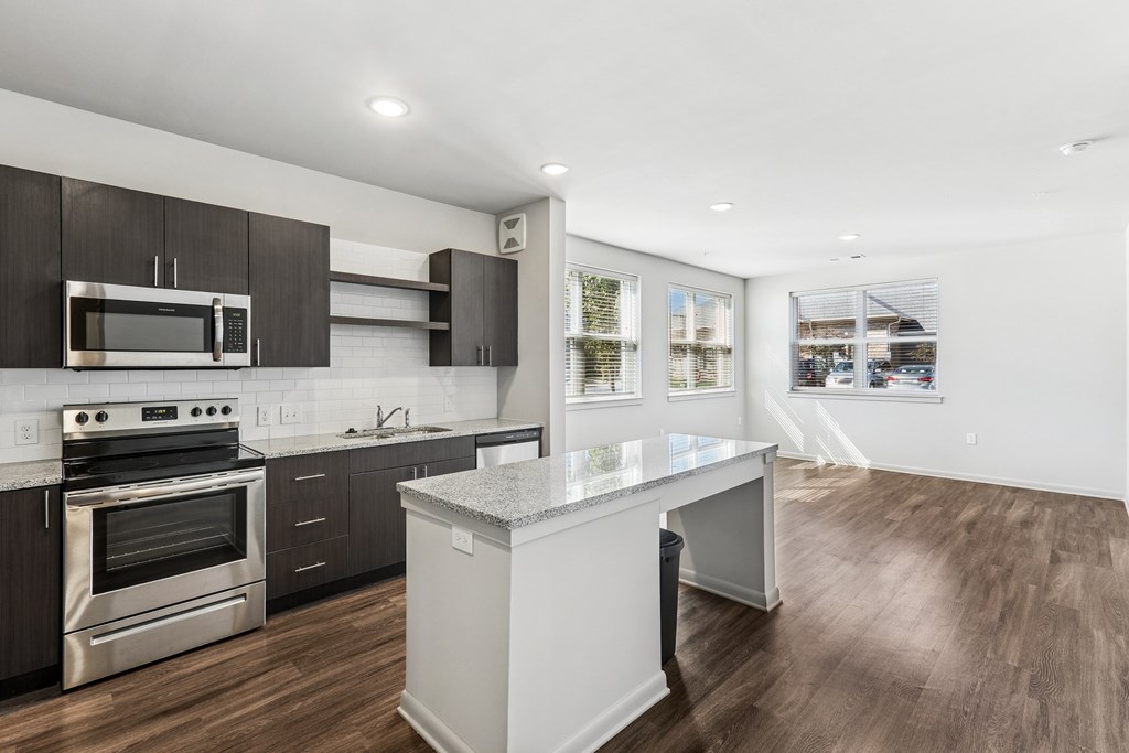 A modern kitchen with dark wood cabinets and stainless steel appliances.
