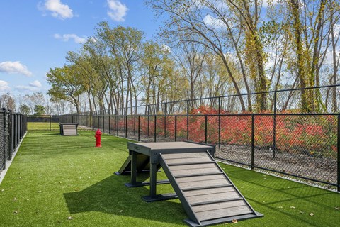 A playground with a slide and a red fire hydrant.