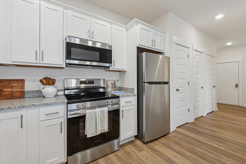 A kitchen with white cabinets and stainless steel appliances.