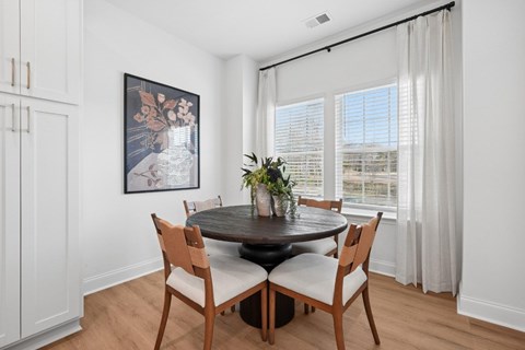 A dining room with a round table and chairs.