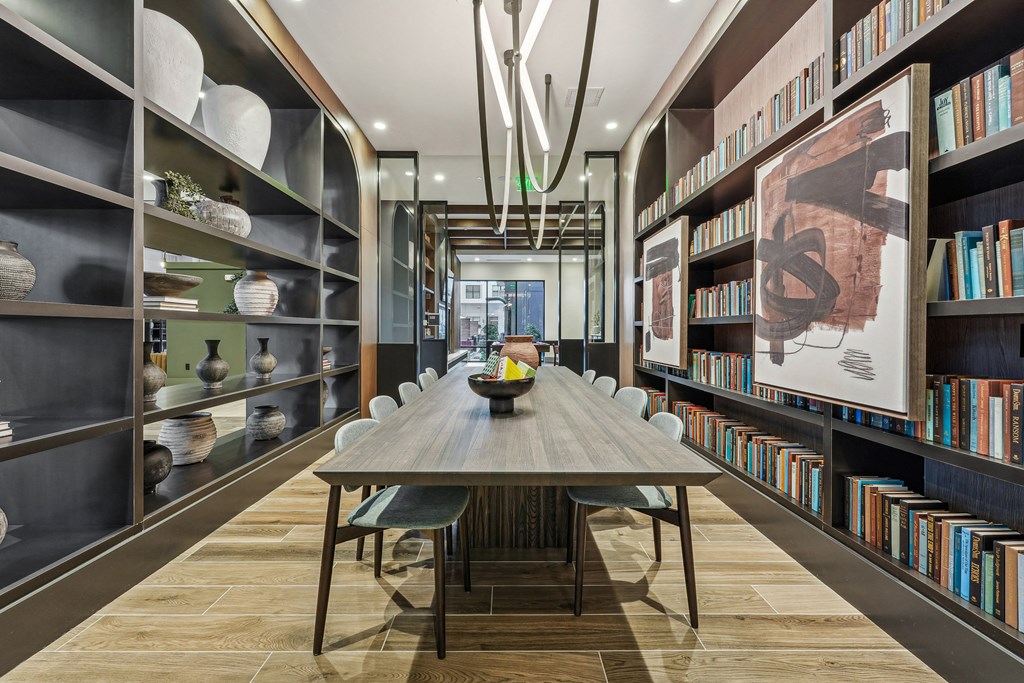a dining room with a long table and bookshelves