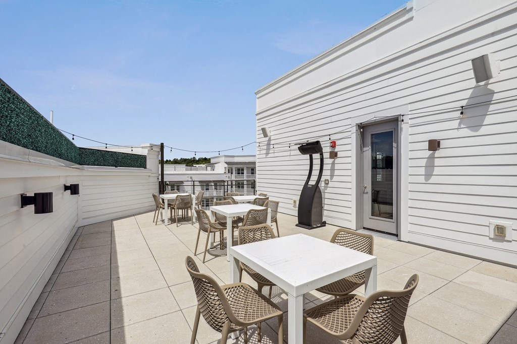 a patio with tables and chairs and a guitar on the side of a building