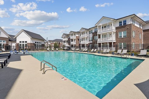 A large swimming pool in front of apartment buildings.