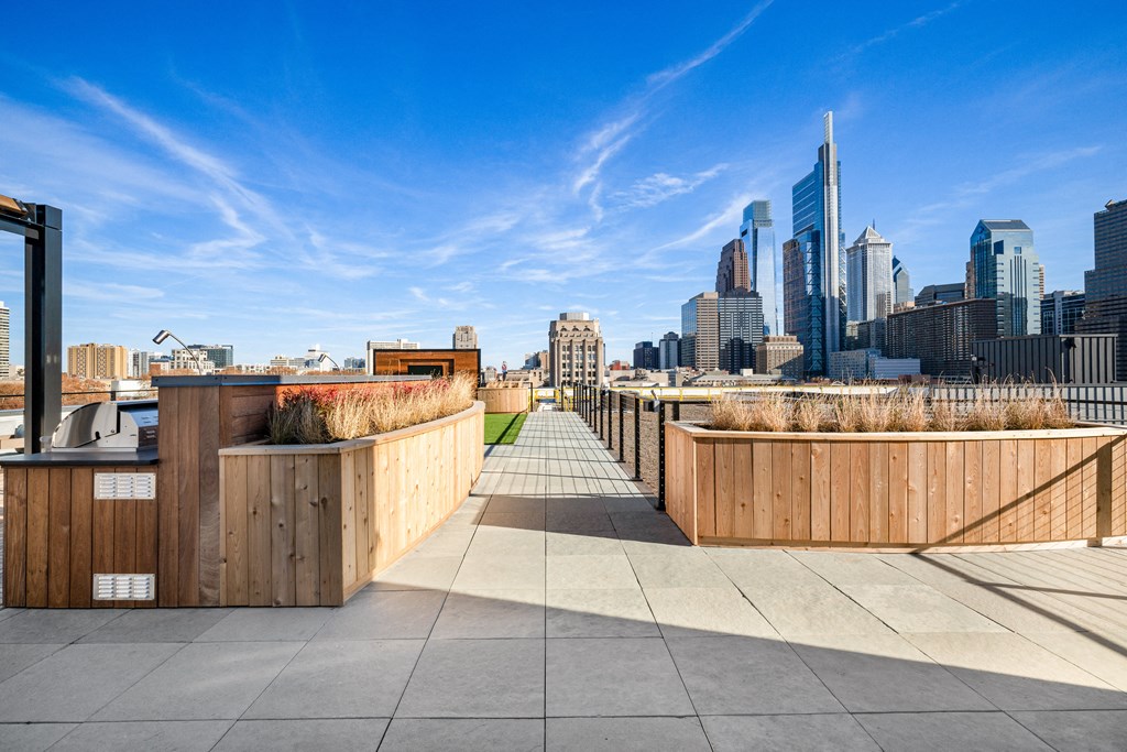 a view of the city skyline from a roof terrace with wooden barriers