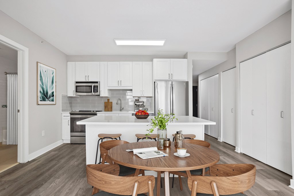 A modern kitchen with a dining table set for two.