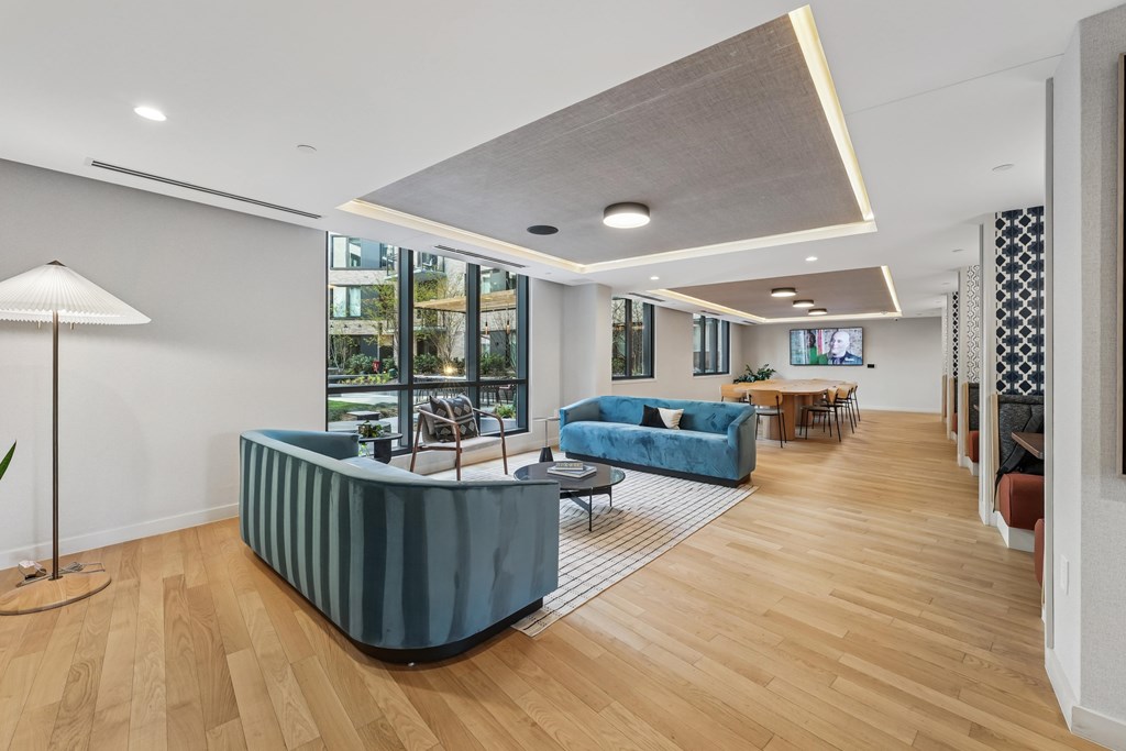 A modern living room with a blue sofa and wooden floors.