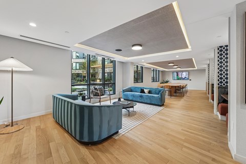 A modern living room with a blue sofa and wooden floors.