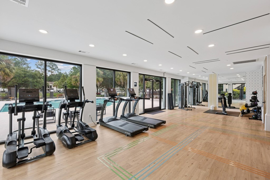 A gym with treadmills, elliptical machines, and other exercise equipment.