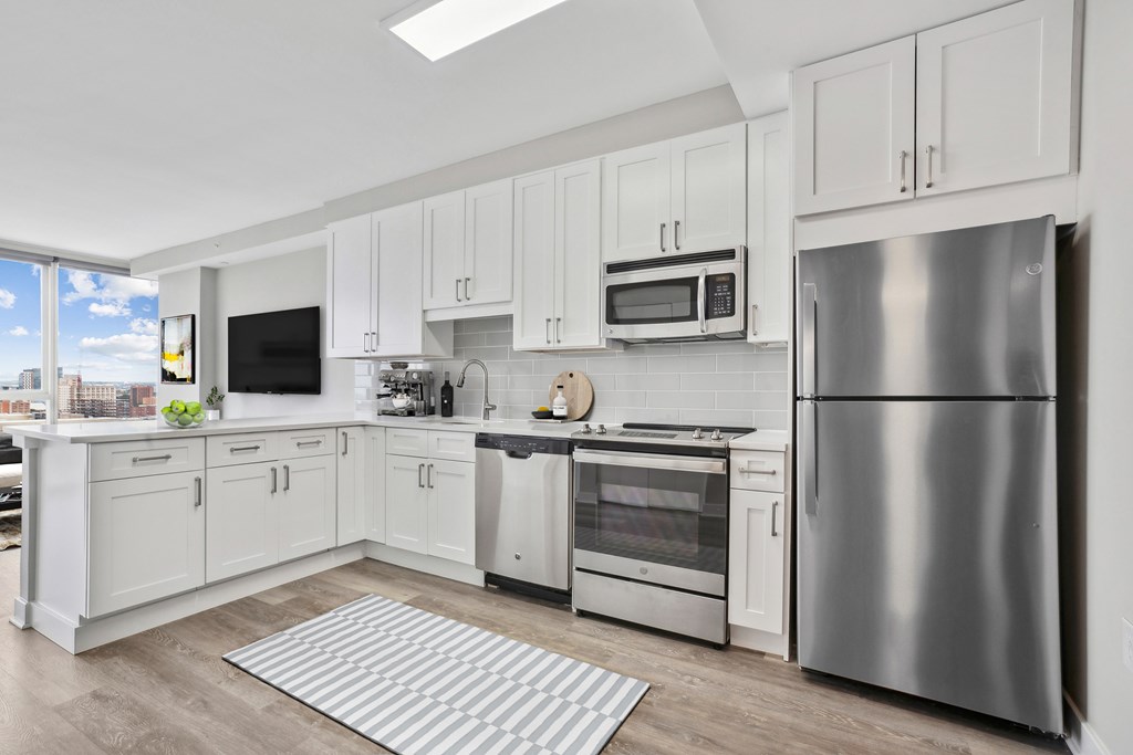 A modern kitchen with stainless steel appliances and white cabinets.