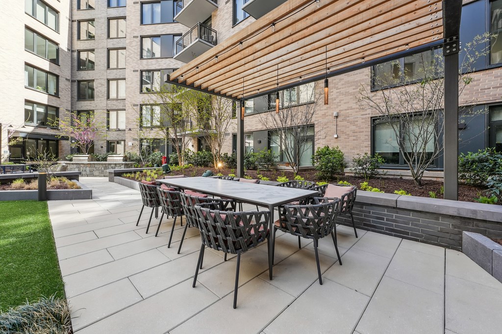 A patio with a table and chairs is surrounded by a brick building.
