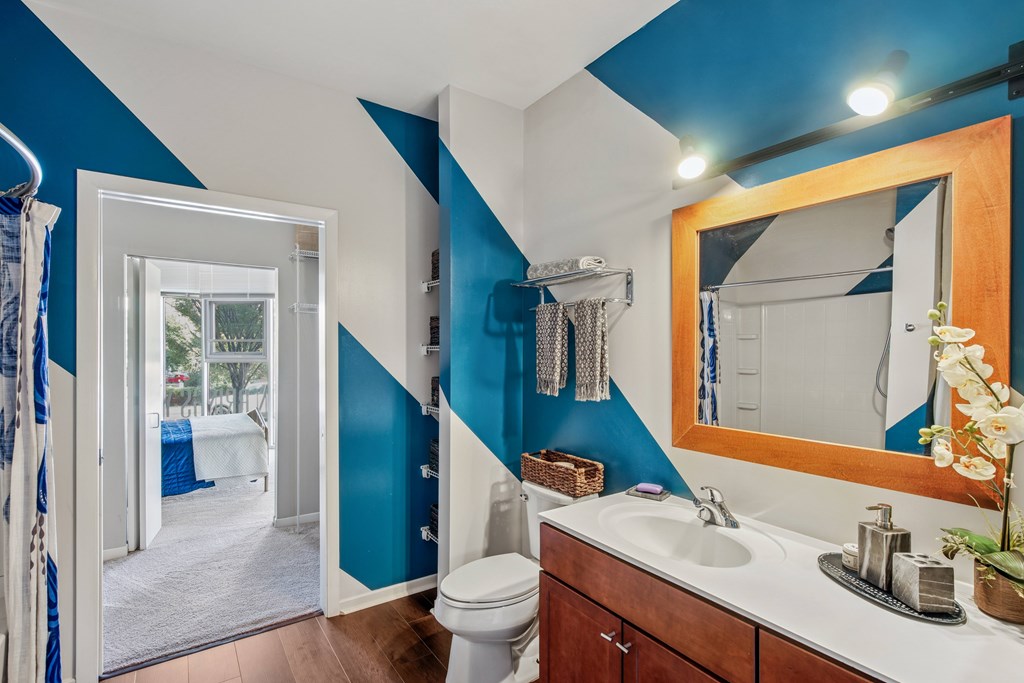 A bathroom with blue and white walls and a wooden vanity.