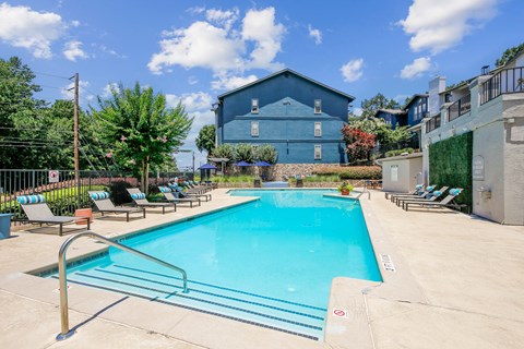 A blue building with a pool in front of it.