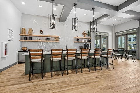 A modern dining room with wooden floors and a long table set with chairs.