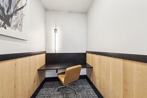 A room with a chair and a table with a black top.