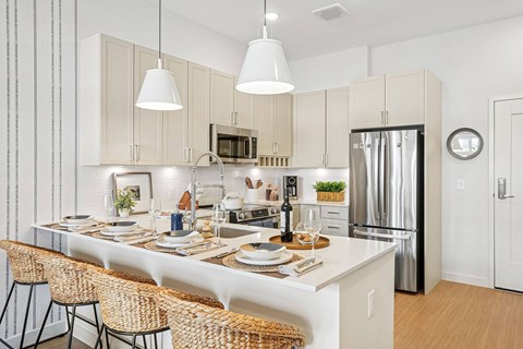 A modern kitchen with a dining table set for two.