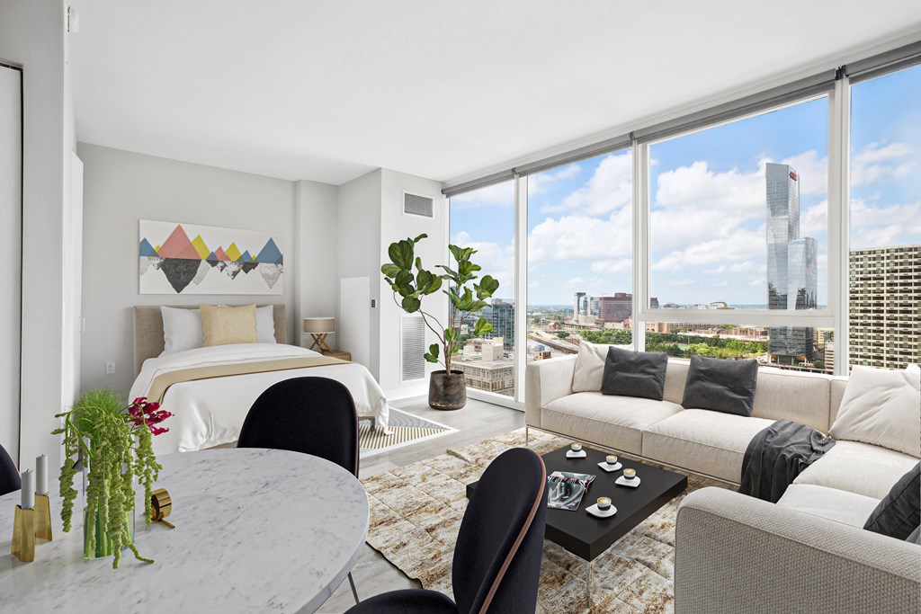 A modern bedroom with a large window overlooking the city.