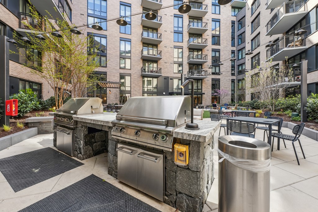 A modern outdoor kitchen with a grill and sink.