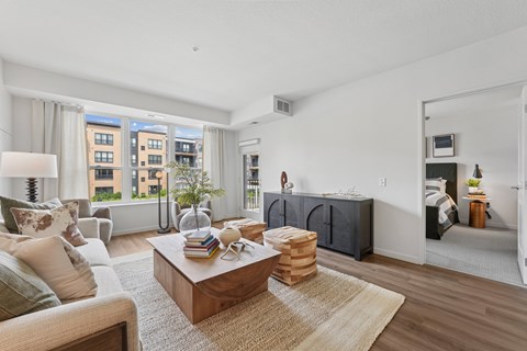 A living room with a brown coffee table and a couch with a white pillow.