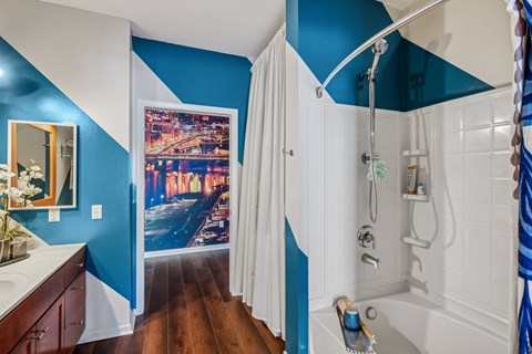 A bathroom with blue walls and a white bathtub.