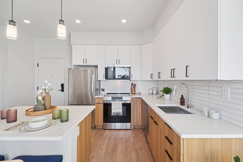 A modern kitchen with white cabinets and a stainless steel refrigerator.