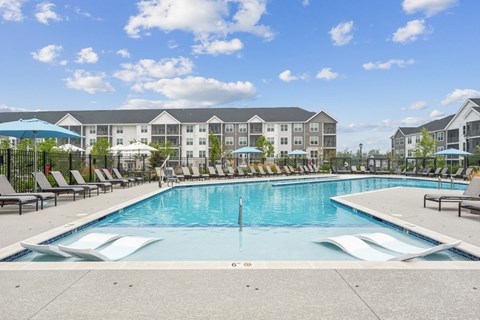 A large swimming pool in front of apartment buildings.