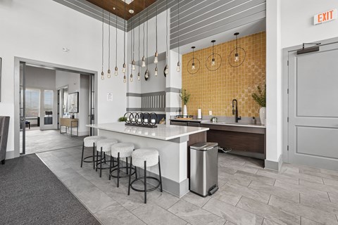A modern kitchen with a bar area and a white countertop.
