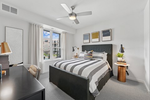 A bedroom with a large bed and a ceiling fan.