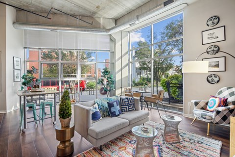 A living room with a couch, chairs, and a table with a plant on it.
