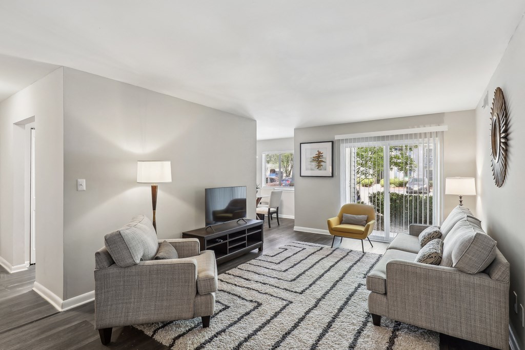 a living room with couches and chairs and a rug