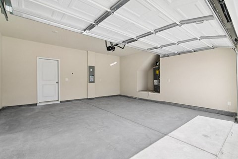 A spacious garage with a white ceiling and a white door.