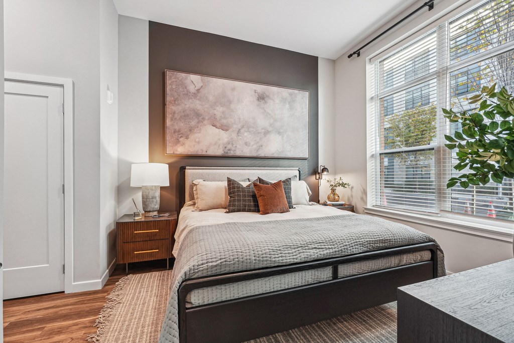 a bedroom with a bed and two windows