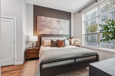 a bedroom with a bed and two windows