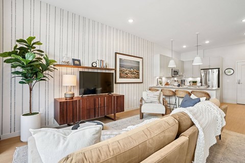 A living room with a brown couch and a wooden cabinet.