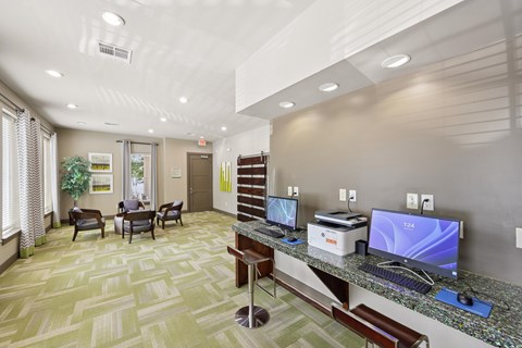 A well-lit office space with a desk, chairs, and a computer monitor.
