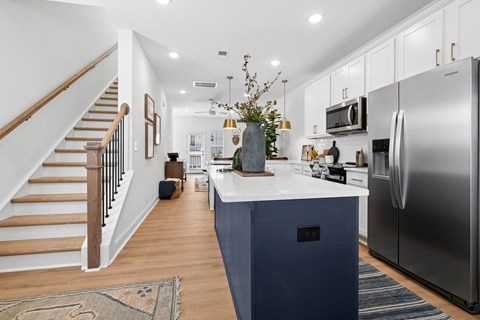 A kitchen with a blue island and stainless steel appliances.