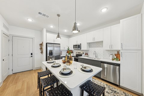 A kitchen with a table set for two with a view of the stove.