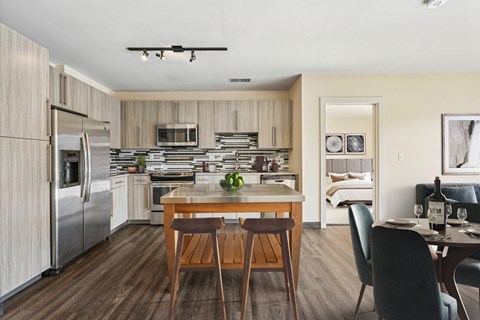 A modern kitchen with a dining table set for two.