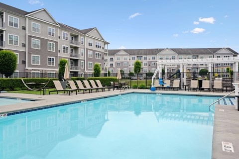 A large swimming pool in front of apartment buildings.
