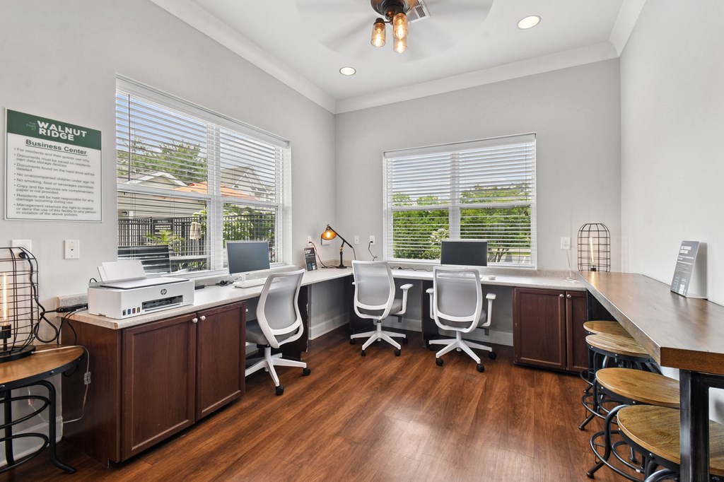 A well-lit office space with a desk, chairs, and a printer.