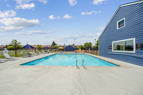 A swimming pool with a blue sky and clouds in the background.