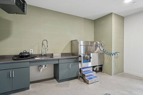 A modern kitchen with a stainless steel sink and a large industrial-style dishwasher.