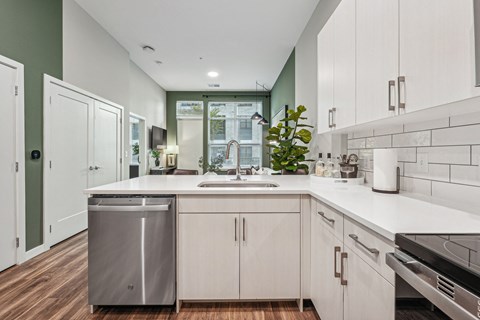 an open kitchen with white cabinets and a sink and a window
