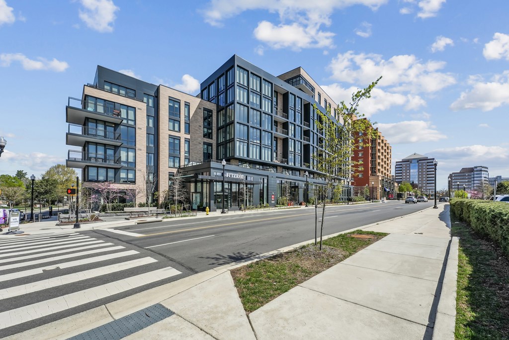 A modern building with glass windows is situated on a street corner.